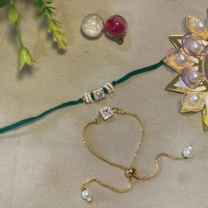 Green thread rakhi with a crystal pendant beside a matching gold bracelet