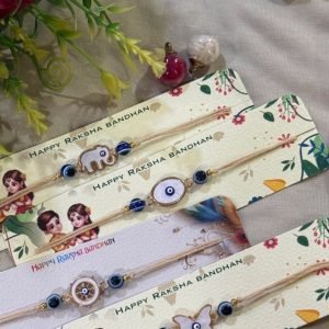 Set of four kids rakhis with elephant, evil eye, wheel and butterfly charms