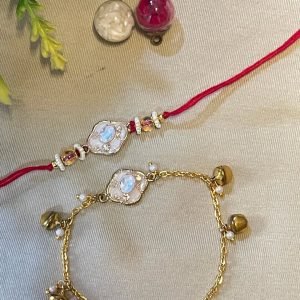 Red thread rakhi with an opal pendant beside a matching gold anklet with bells