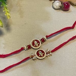 Red thread rakhi with a round kundan pendant and pearls